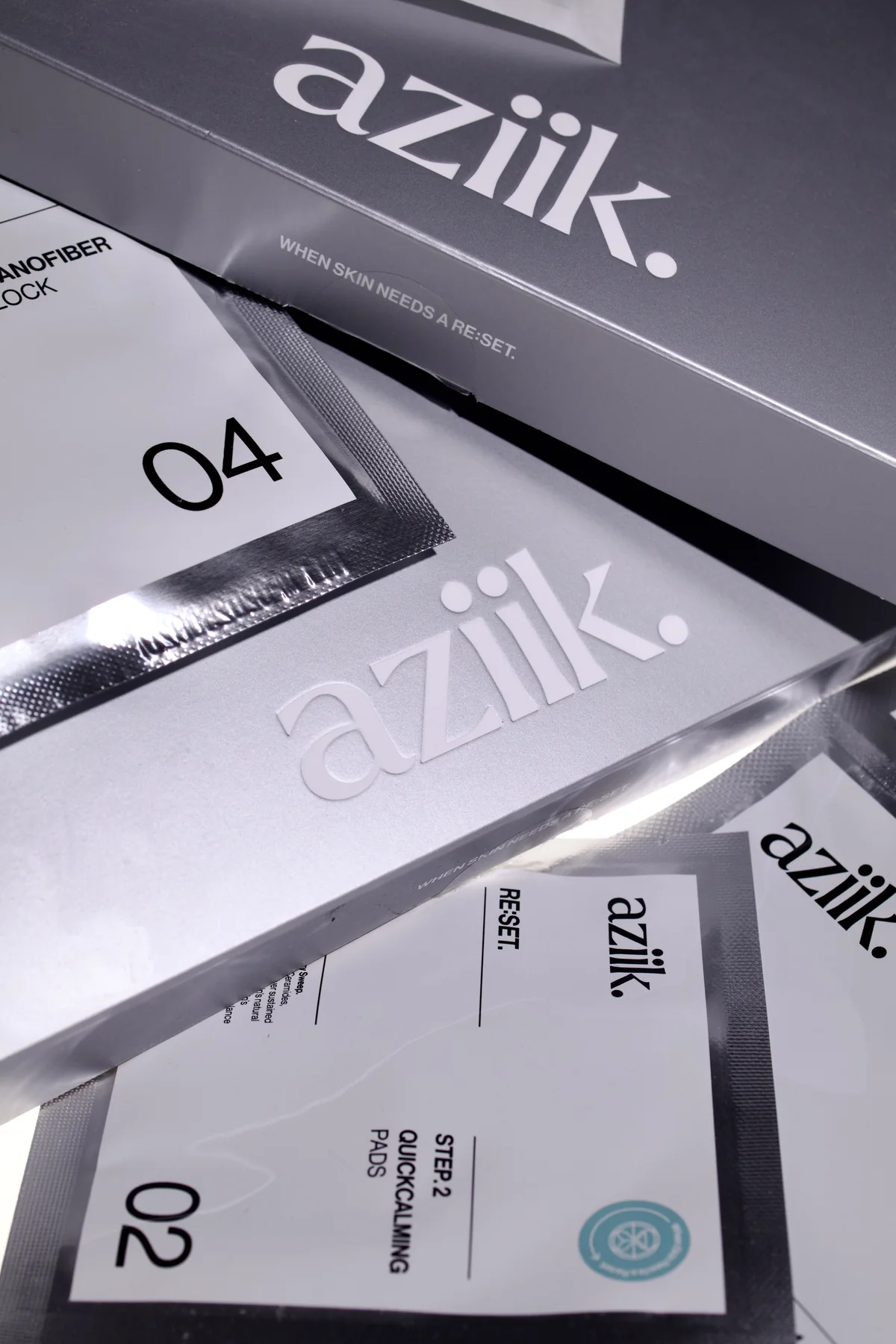Aziik hair-colour packages styled in a monochrome product layout